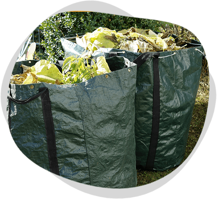 Two green garbage bags with leaves in them.